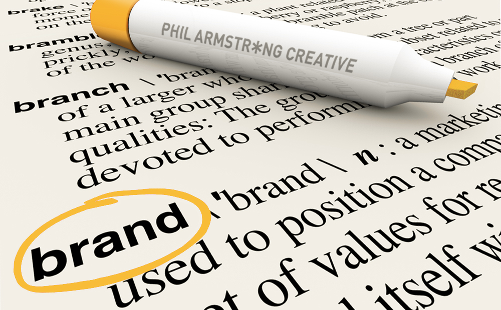 Phil Armstrong Creative's orange marker pen encircles the word Brand in a dictionary.